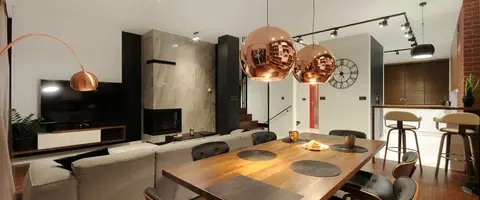 Salon z drewnianym stołem i miedzianymi lampami — realizacja ZoomProjekt
